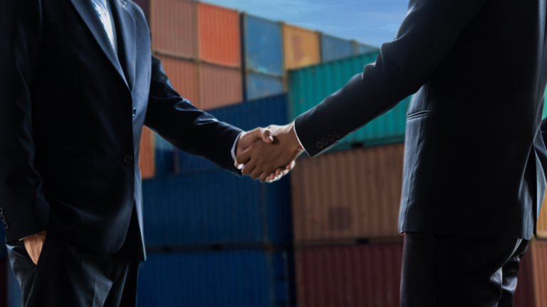 A freight broker and business person shaking hands because of a freight brokerage deal
